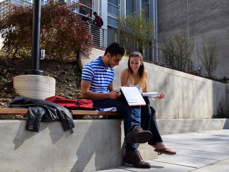 Students sitting on patio reading notes